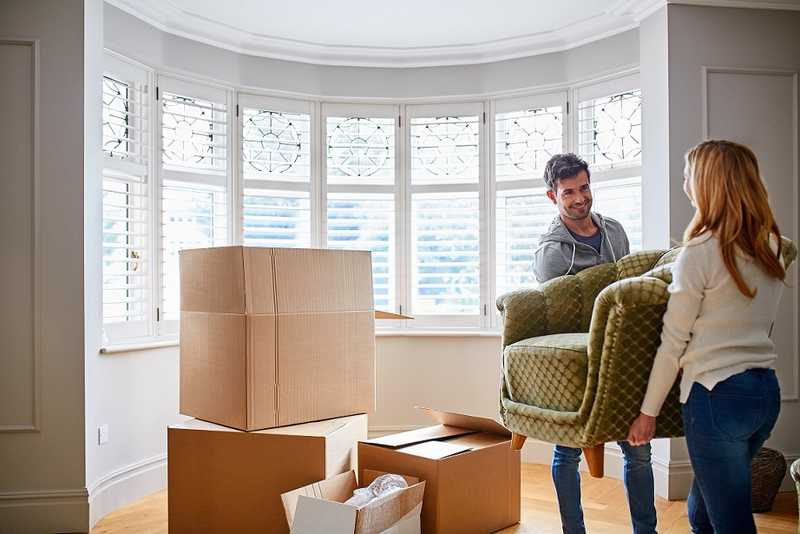 moving furniture to a storage facility A man and a woman transporting a chair